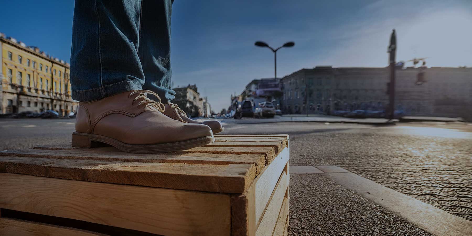 feet standing on a soapbox on a city corner